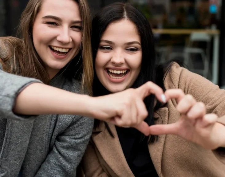 Przyjaciele robią serce palcami